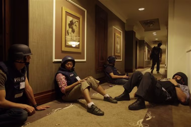 Journalists sit it out in a hallway as gun-battles continue around the Rixos hotel in Tripoli, Libya, Tuesday, Aug. 23, 2011. Dozens of journalists remain trapped inside this hotel as forces loyal to Moammar Gadhafi prevent them from leaving and gun battles with rebel forces continue all around. (AP Photo/Dario Lopez-Mills)